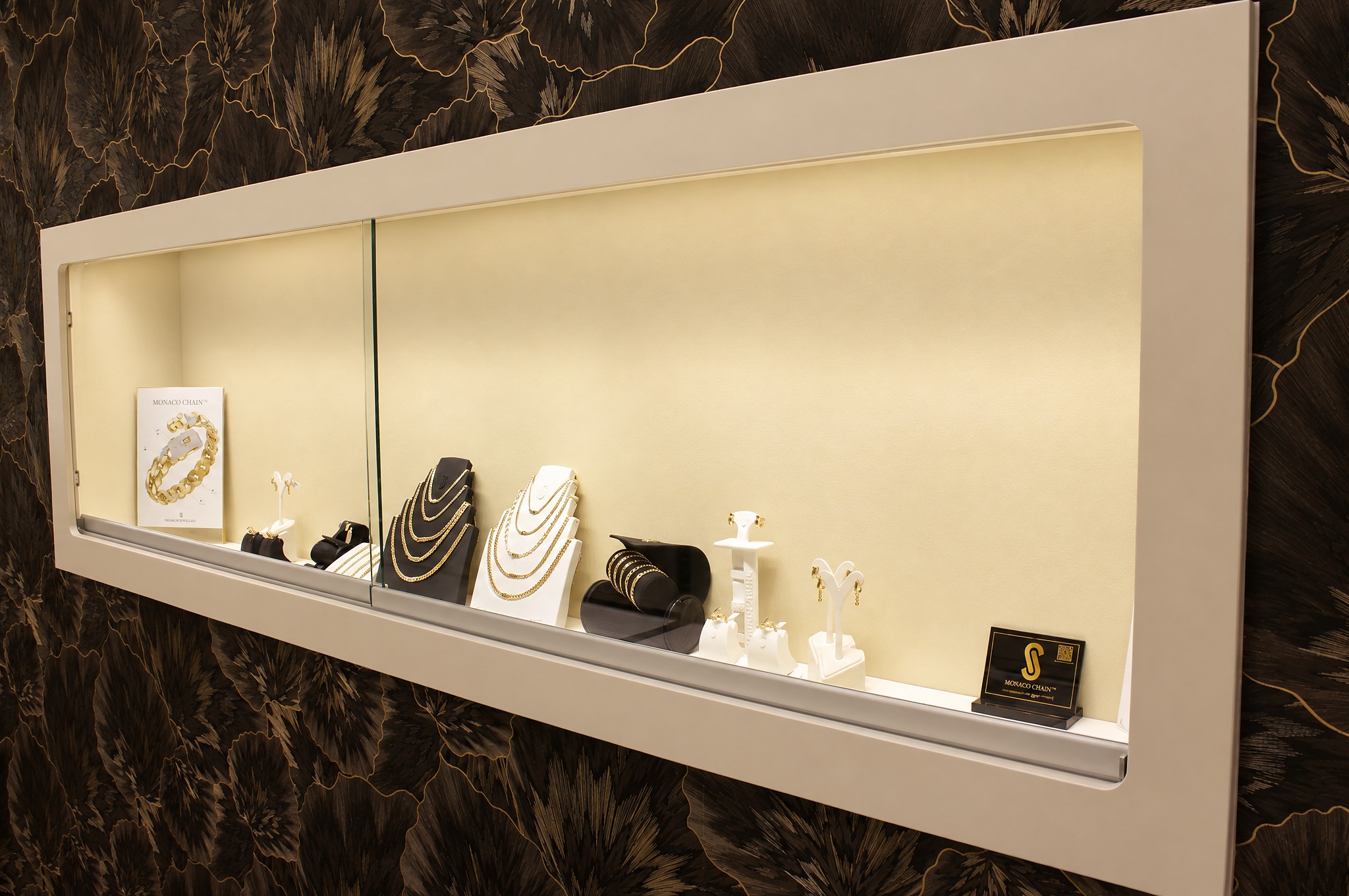 Vitrine mit Monaco-Chain-Schmuck vor der Chrysanthemenwand